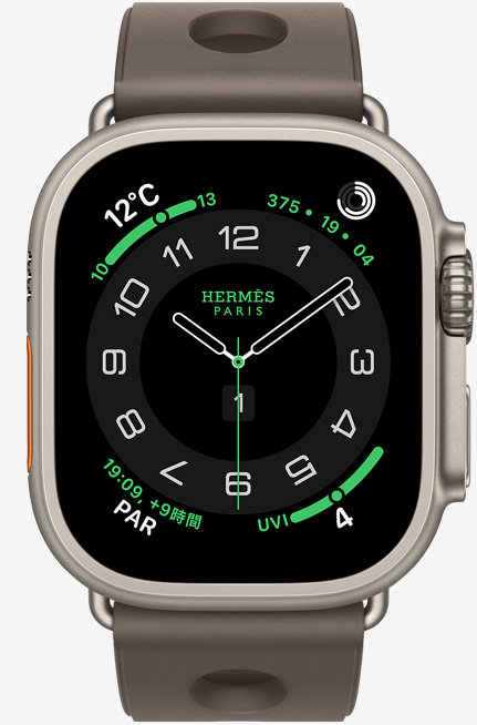 ナチュラルチタニウムケースのApple Watch Hermès Ultra 3。Hermès Circulaireの文字盤に、天気、アクティビティリング、パリの時間、UV指数のコンプリケーションが表示されている。外観の右側には、Digital Crown、マイク、少し突き出たサイドボタンがあり、グリ・チタンのスキュブHダイビングストラップが付いている