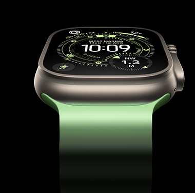 A close-up of a Natural Titanium Apple&nbsp;Watch Ultra&nbsp;3 on a black background. The display shows the time and other dynamic info.