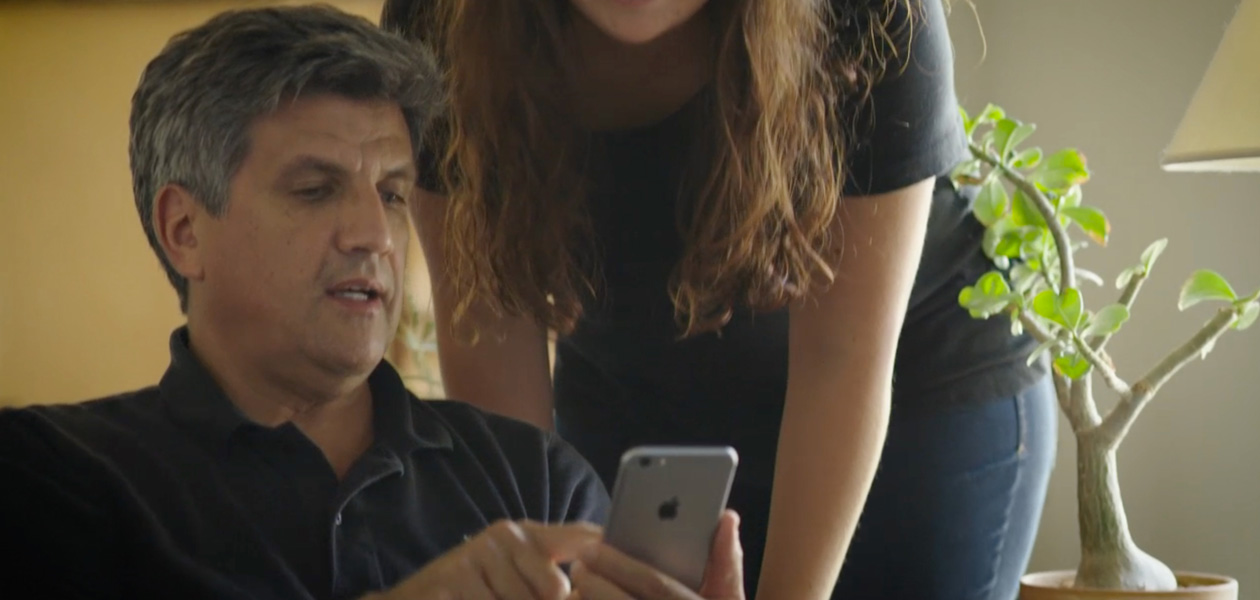 Un homme partage ses données de santé sur iPhone avec la femme se tenant à ses côtés.