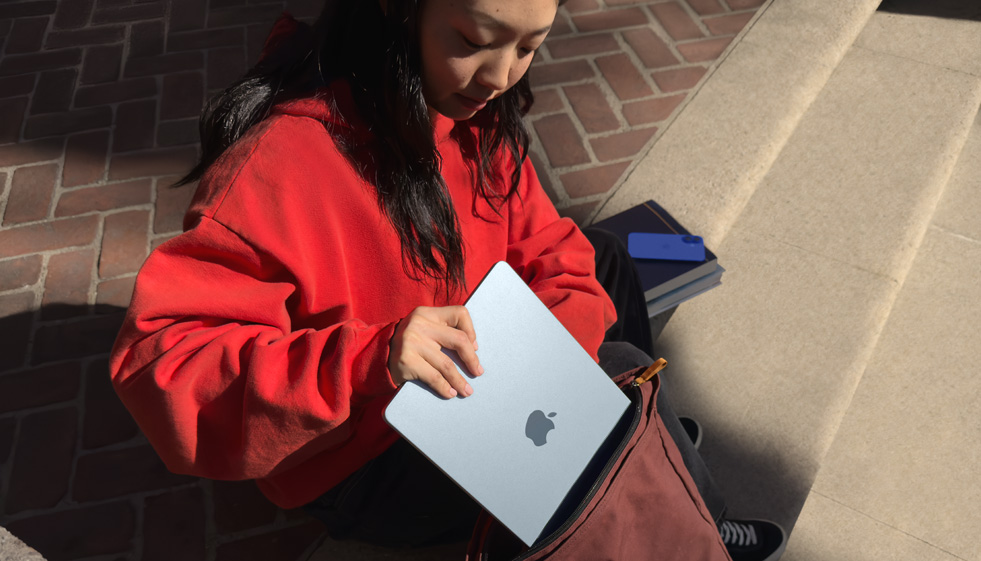Una estudiante guardando una MacBook Air en su mochila