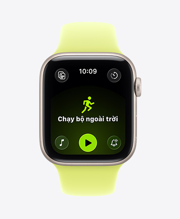 Apple Watch SE 3, vỏ nhôm, màu ánh sao, bài tập Chạy Bộ Ngoài Trời đang mở, các nút điều khiển Apple Music ở cuối màn hình, Dây Đeo Thể Thao, màu vàng dạ quang.